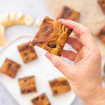 A chickpea blondie studded with chocolate chips being held up to the camera.