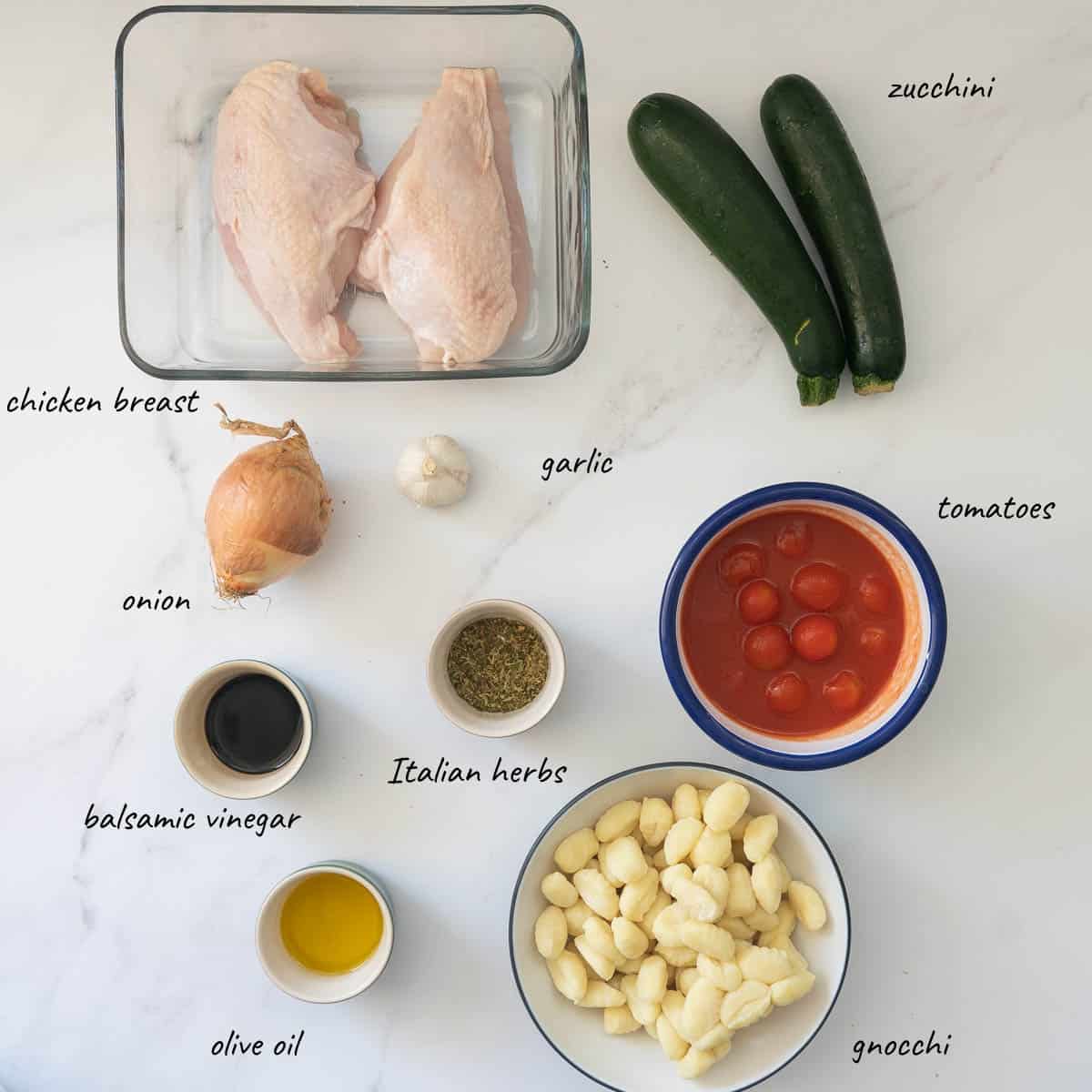 The ingredients to make chicken gnocchi bake laid out on a bench top.
