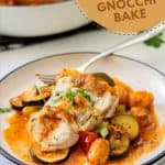 Slices of chicken sitting on a bed of gnocchi in a tomato based sauce, pieces of zucchini visible with text overlay for pinterest