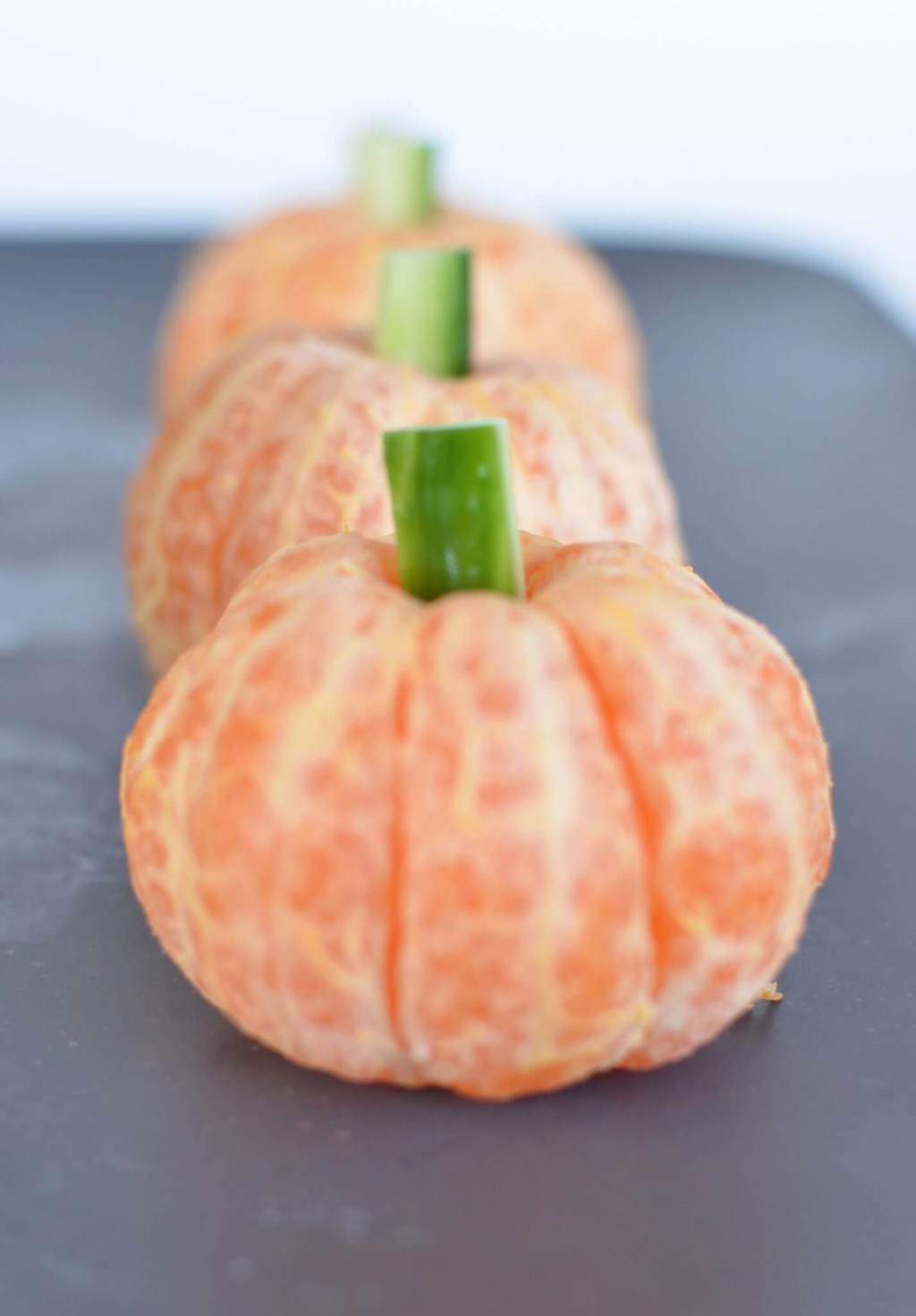 Healthy halloween treats with fun pumpkins made from mandarins