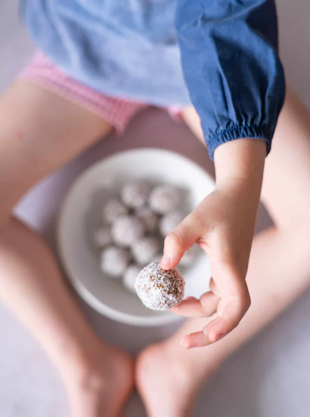 Child holding a carrot bliss ball