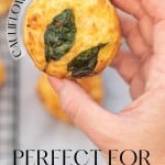 An egg muffin topped with spinach leaves being held up to the camera with text overlay for pinterest.