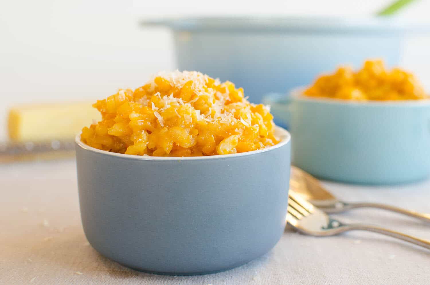 A small blue ramekin filled with pumpkin risotto.