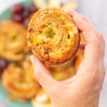 A wholemeal scroll filled with leek and cheese being held up t o the camera.