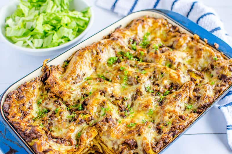 cooked lasagne in a blue dish sprinkled with parsley