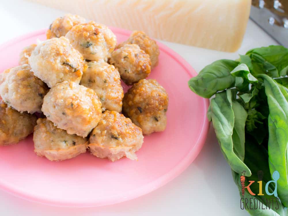 A plate of Parmesan chicken basil baked meatballs on a pink plate.