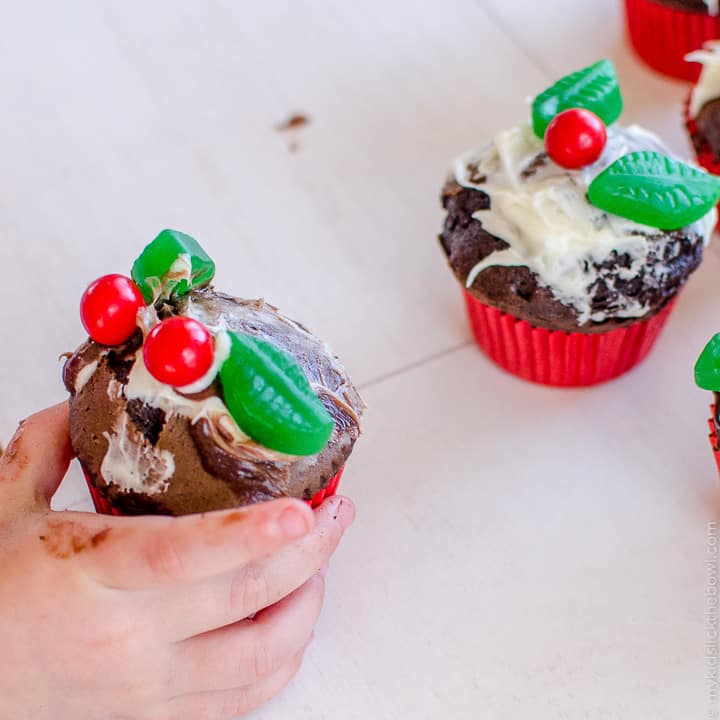 A cupcake messily decorated with candy and frosting by a child to look a little like a figgy pudding. 