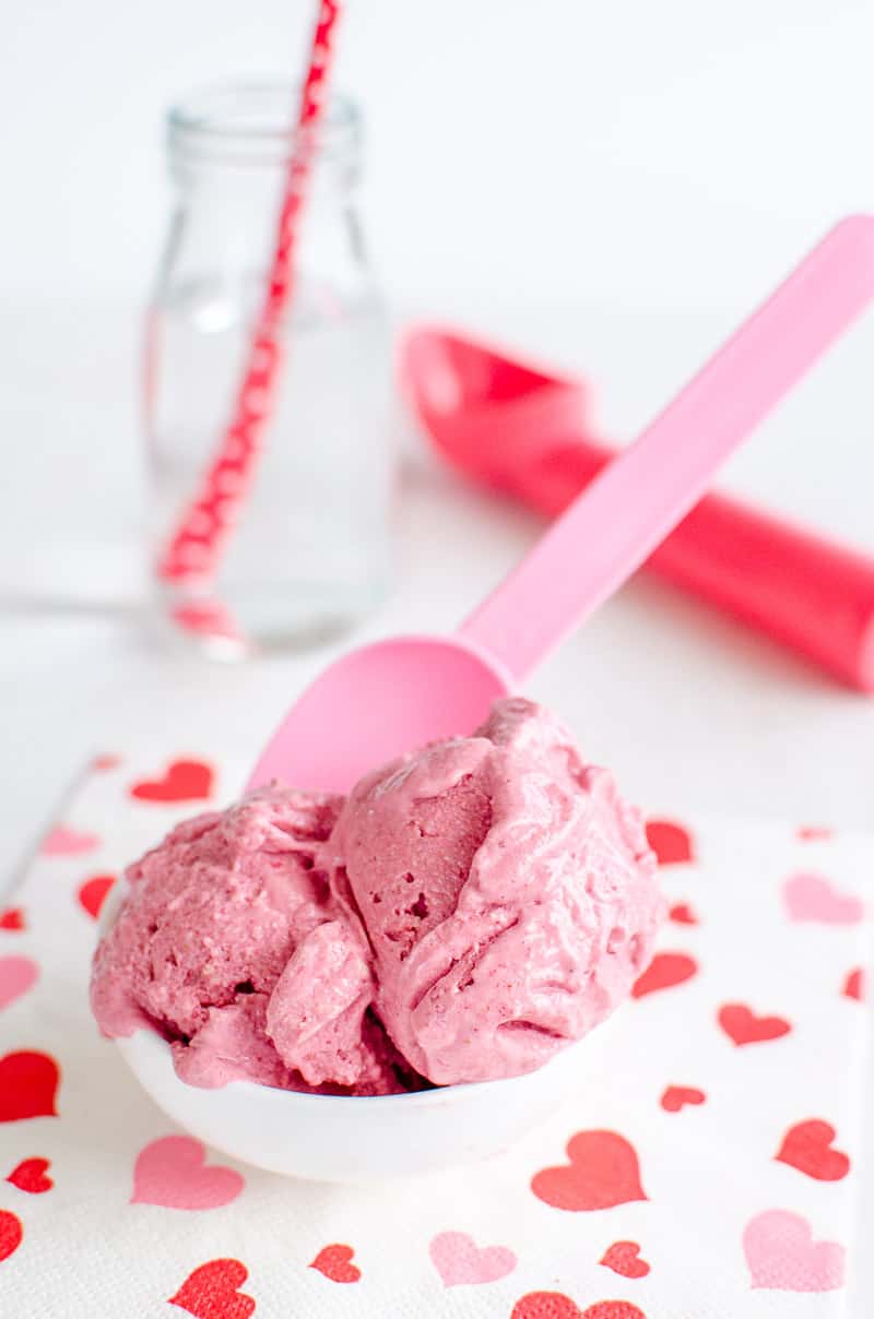 bowl of strawberry ice cream sitting on a pink and white napkin
