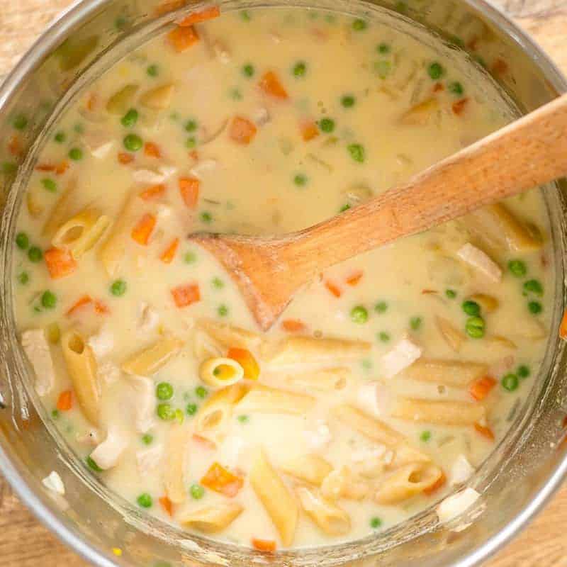 creamy chicken pasta soup, close up of soup cooking in the pot, cream base, chicken, vegetables and pasta