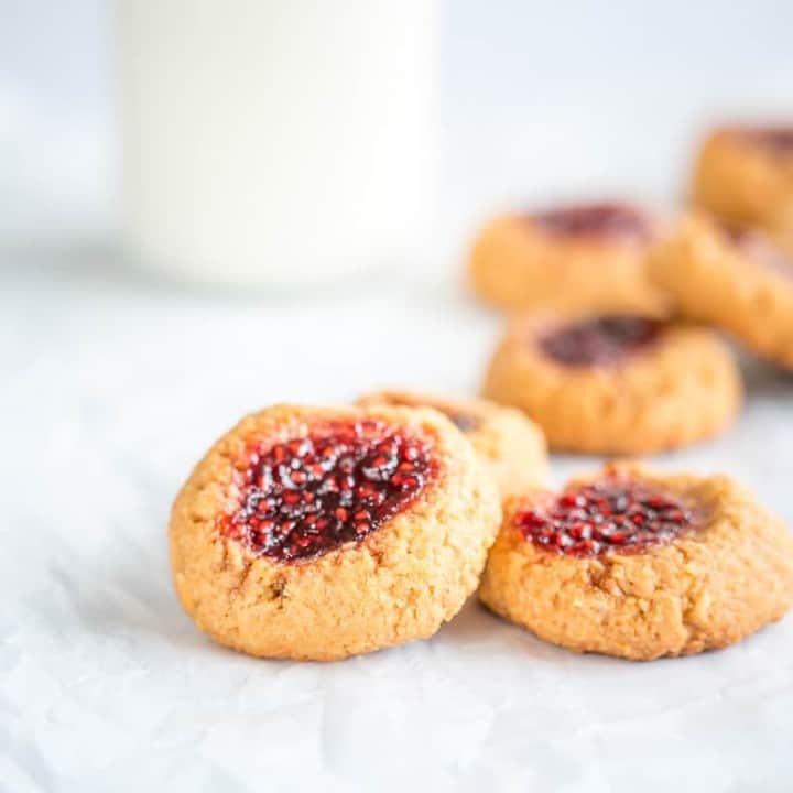 Peanut Butter and Jam Thumbprint Cookies, close up of three cookies on a white surface