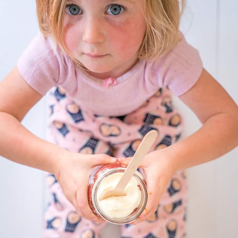 Strawberry Chia Yoghurt Parfait held by young girl in pink pyjamas
