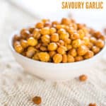 Crunchy garlic roasted chickpeas, in a small white bowl on a linen surface
