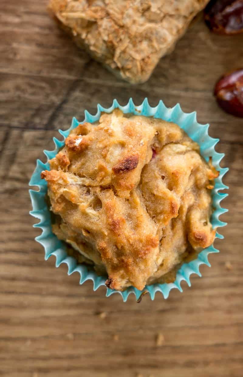 date and apple muffin on wooden background with blue muffin liner