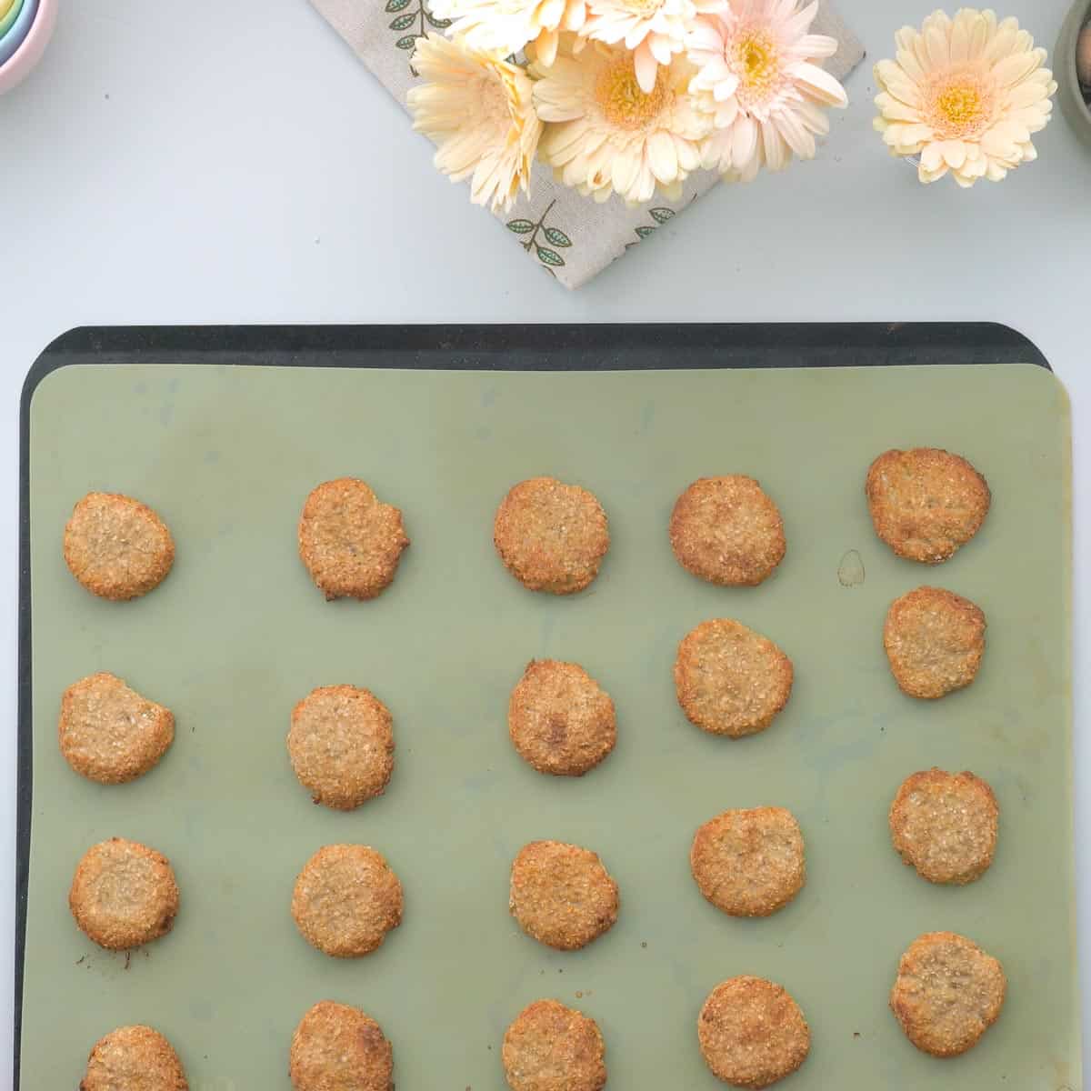 Golden brown oatmeal cookies on a lined cookie sheet.
