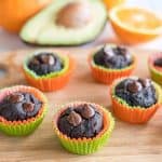 Avocado muffins on a wooden chopping board oranges and avocado in background