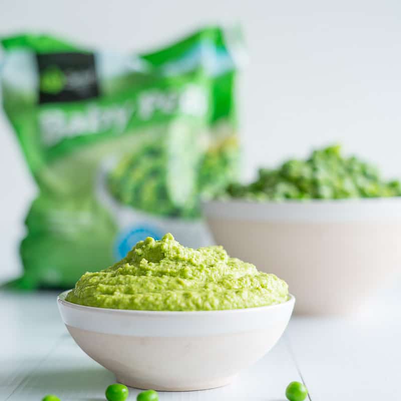 Pea pesto with frozen peas in the background