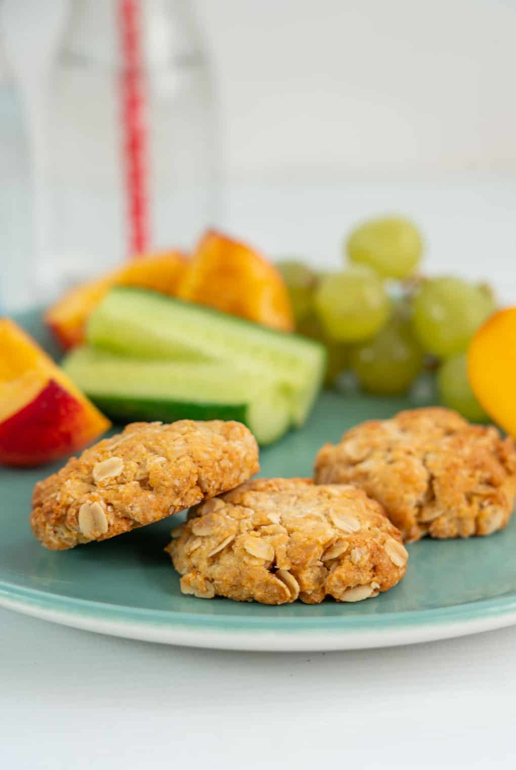 Snack plate of anzac biscuits with fruit and vegetables