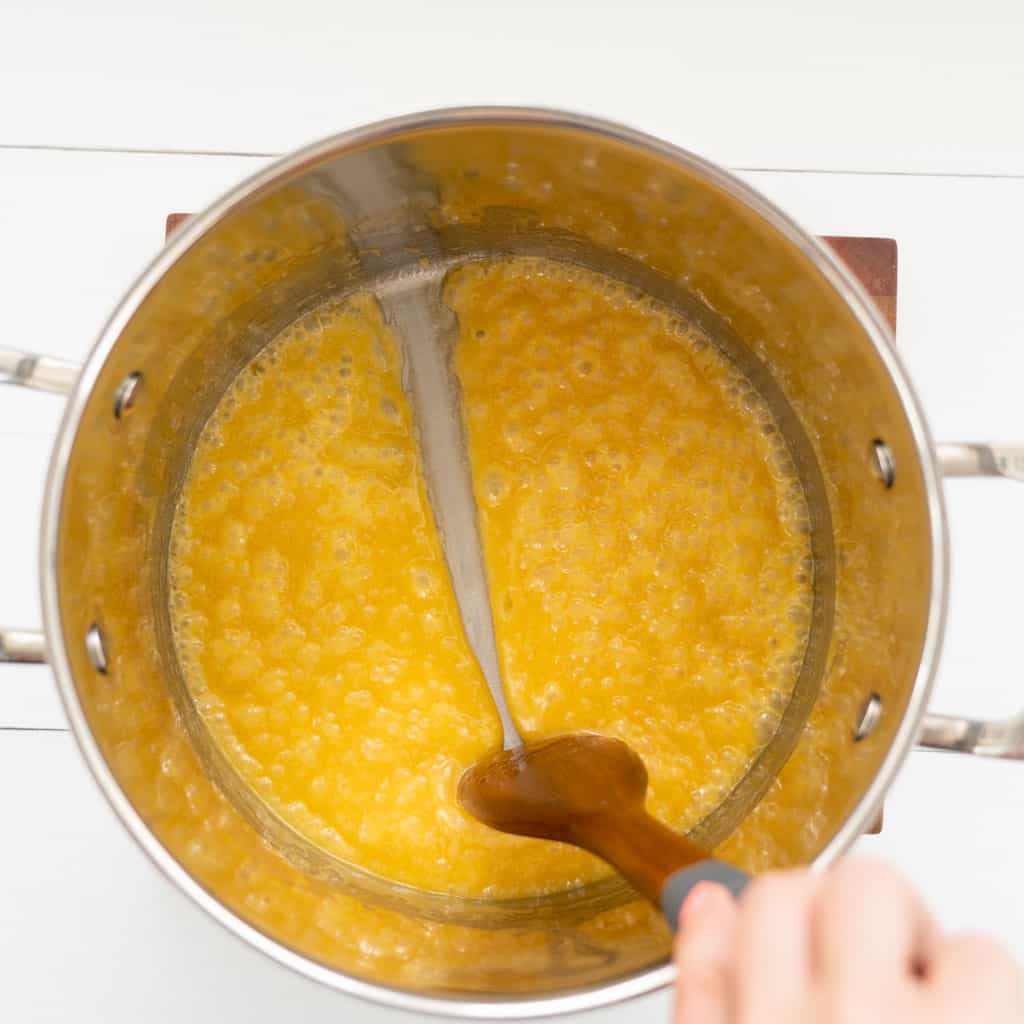 wooden spoon being drawn through melted butter honey and sugar