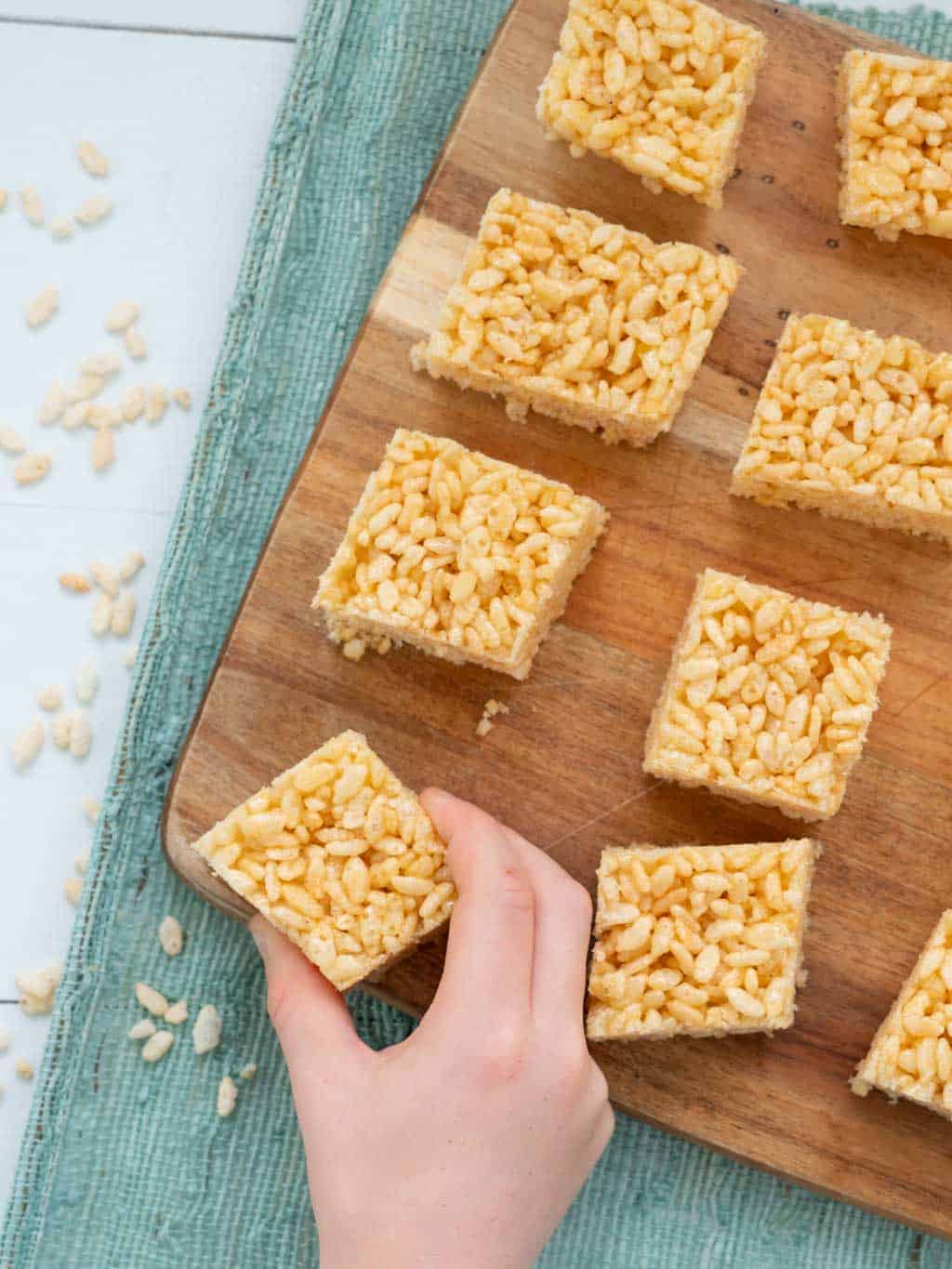 rice bubble slice on a board, child's hand picking up one piece