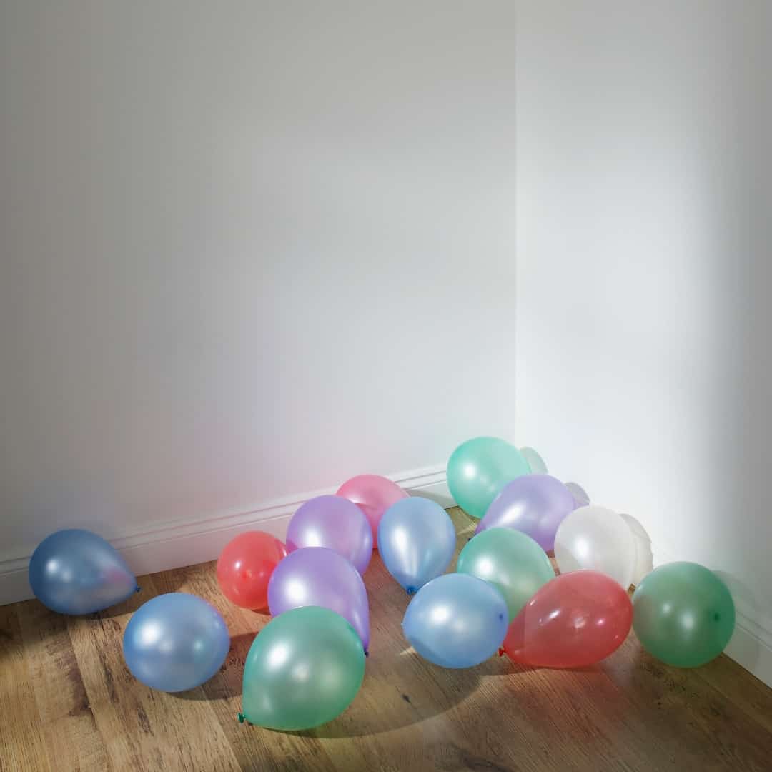 balloons on the floor in the corner of a living room