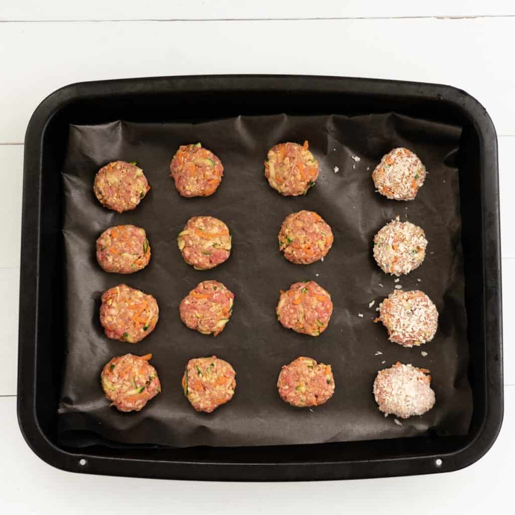 Tray of rissoles ready to go into the oven, 12 are plain and 4 are crumbed