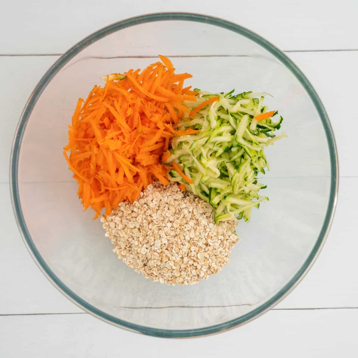 Mixing bowl with grated carrot, grated zucchini and oats