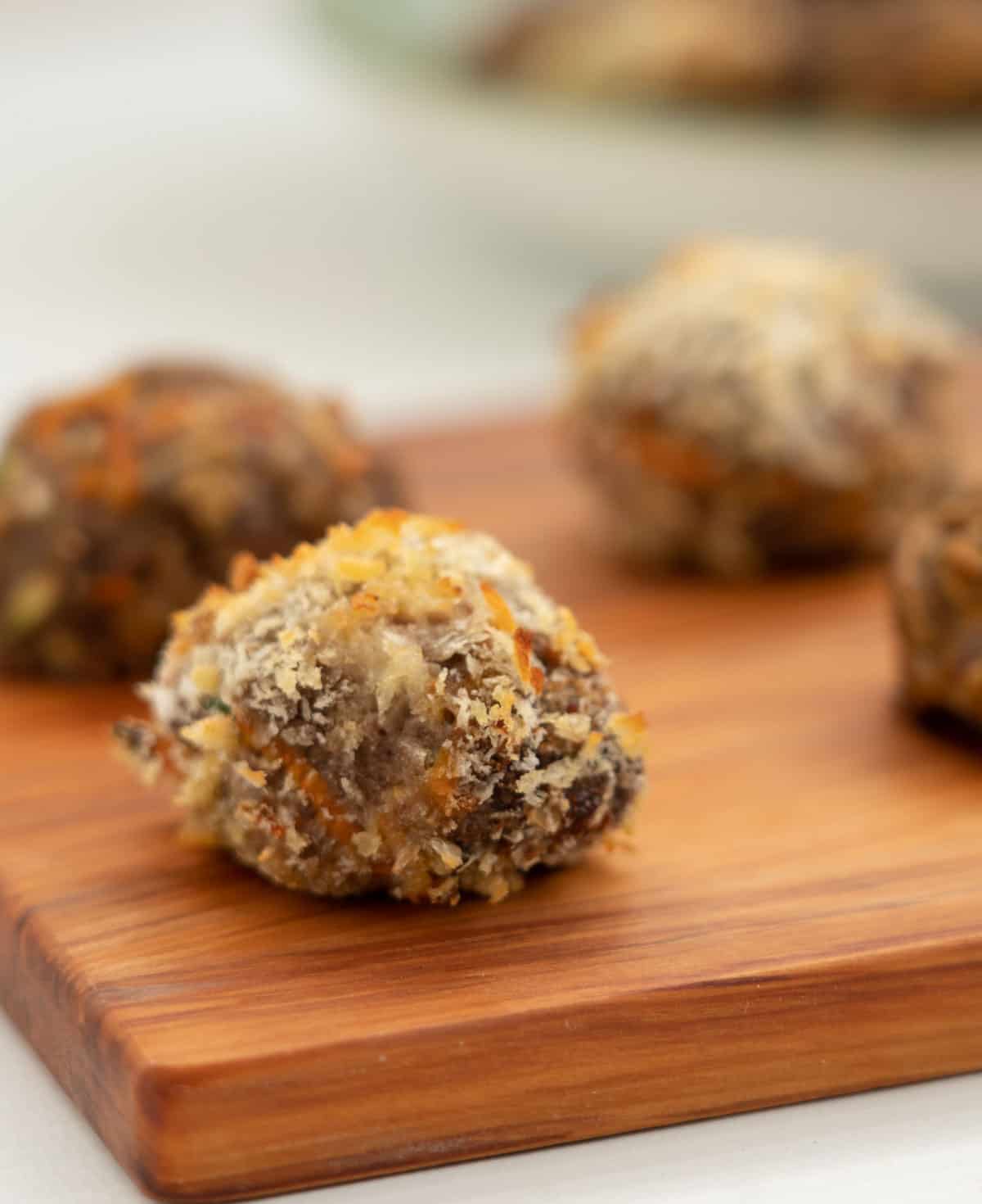 crumbed rissole sitting on a wooden board