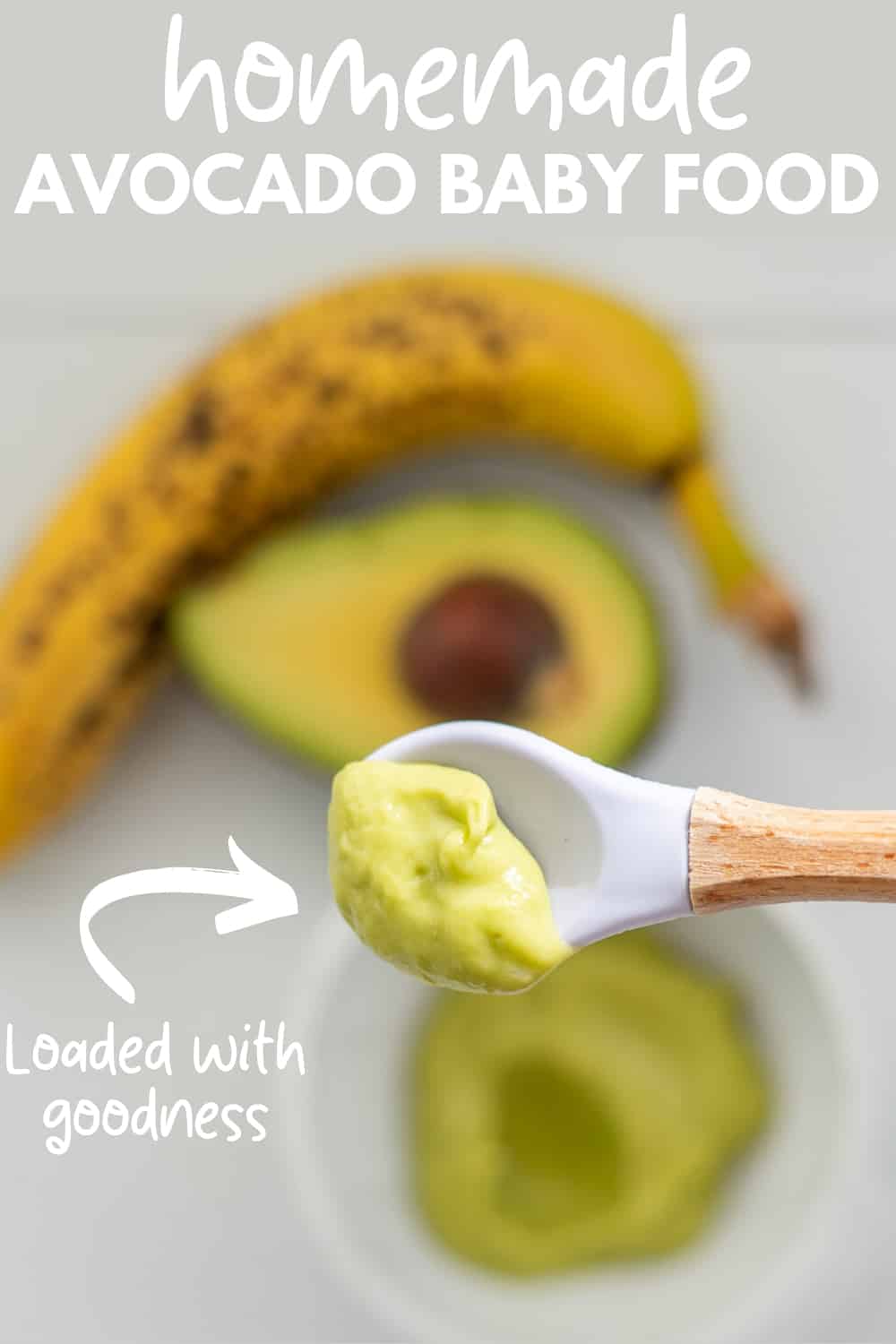 Smooth creamy green avocado and banana puree on a bamboo handled silicone baby spoon