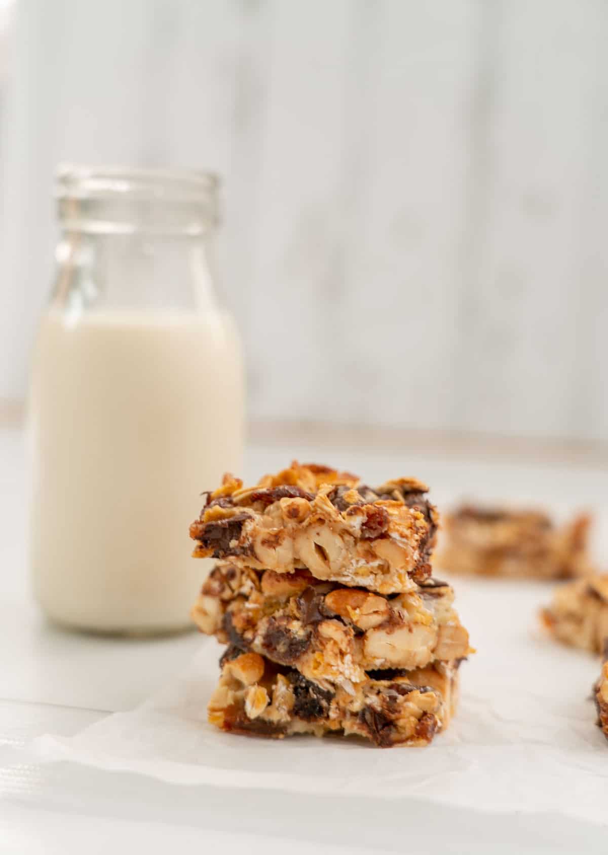 3 pieces of condensed milk slice stacked in a tower, sitting next to a small glass bottle of milk