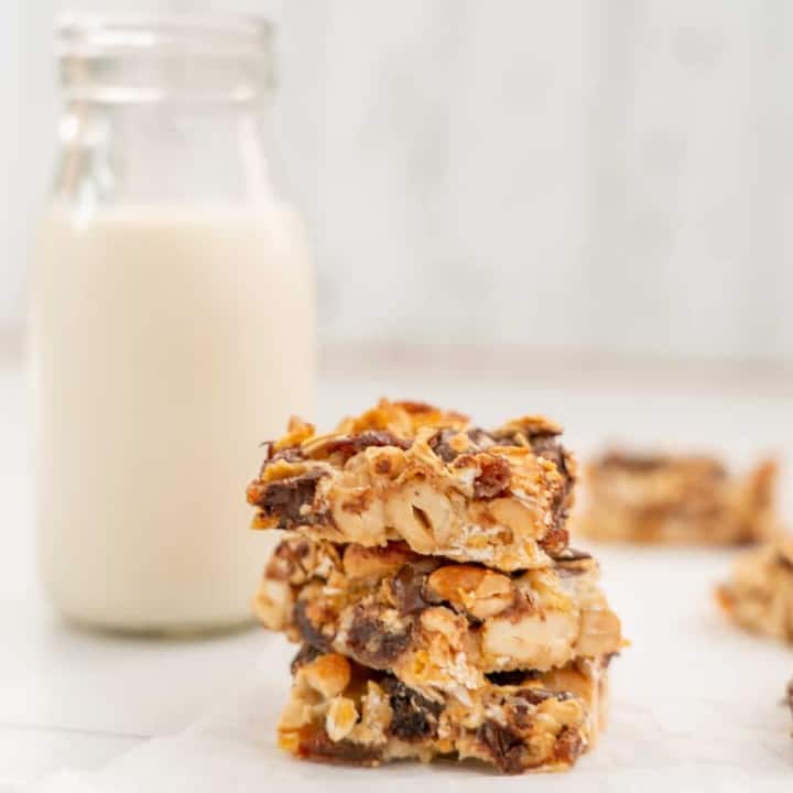 3 pieces of condensed milk slice stacked in a tower, sitting next to a small glass bottle of milk