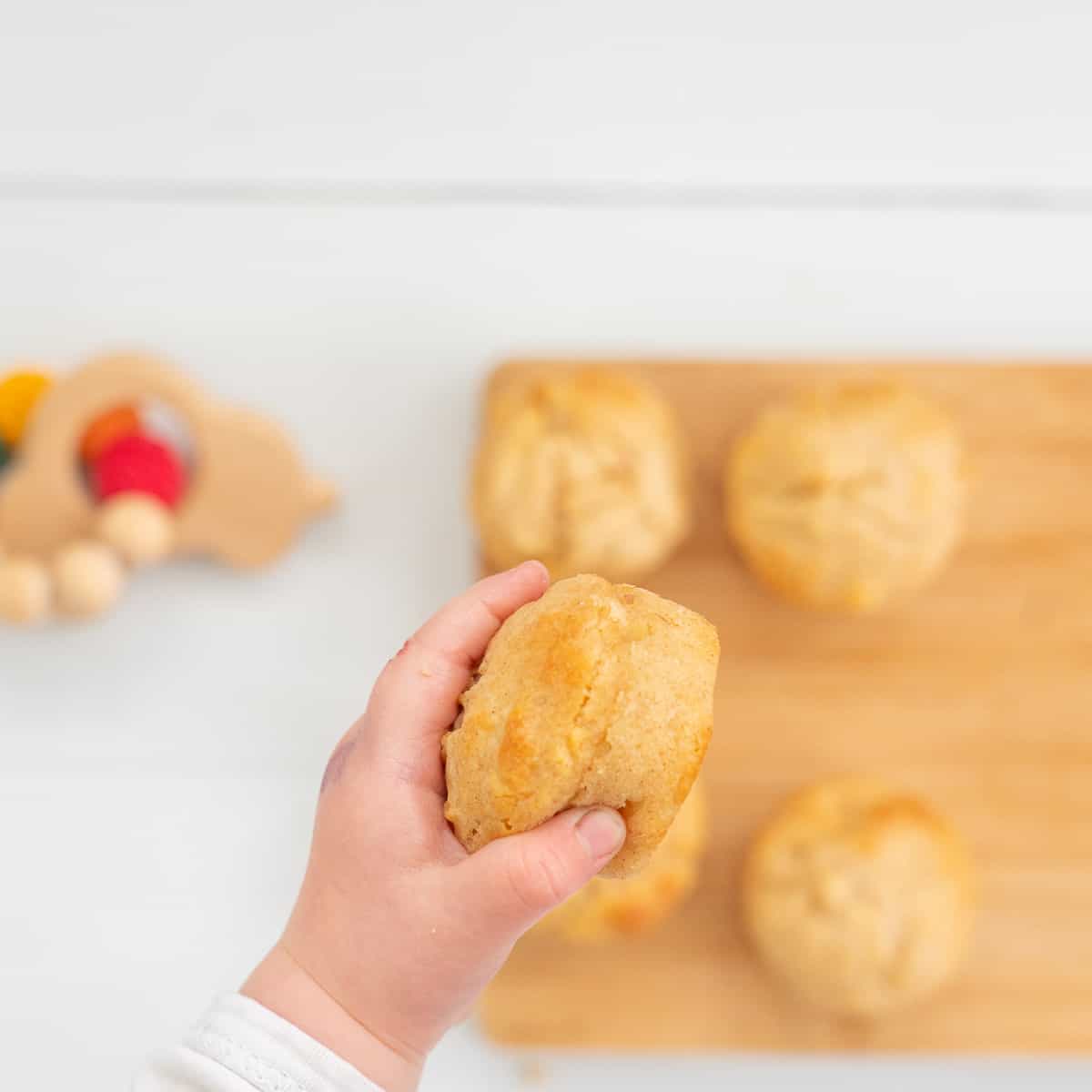 baby hand holding a muffin