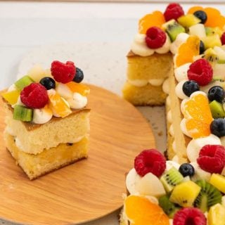 slice of fruit decorated cake next to a number 1 birthday cake