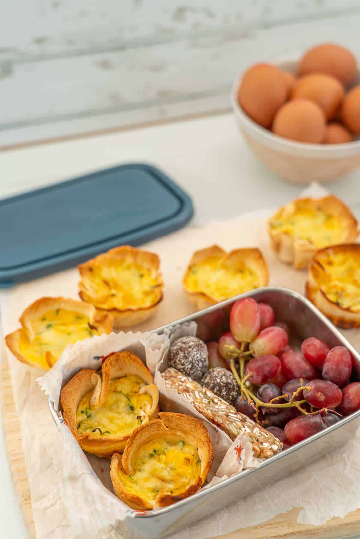 mini quiches in a lunchbox with a granola bar and grapes