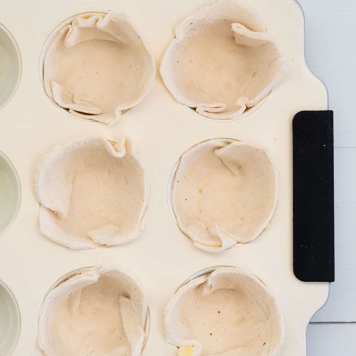 Bread pushed into muffin tins, un-coocked