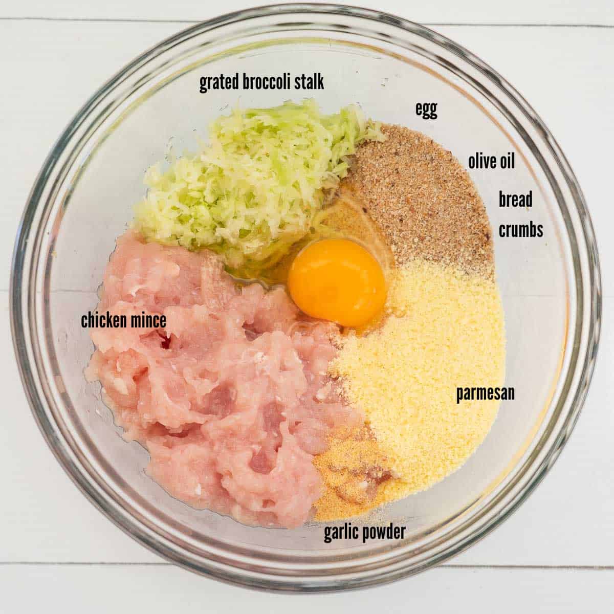 bowl with chicken mince, egg, bread crumbs, olive oil, parmesan cheese, garlic powder, grated broccoli stalk