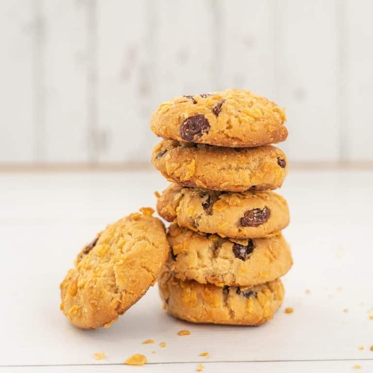 stack of 5 cornflake cookies on a white background, raisins visible.