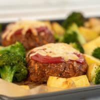 meatloaf topped with tomato ketchup and grated cheese with roast potatoes and broccoli