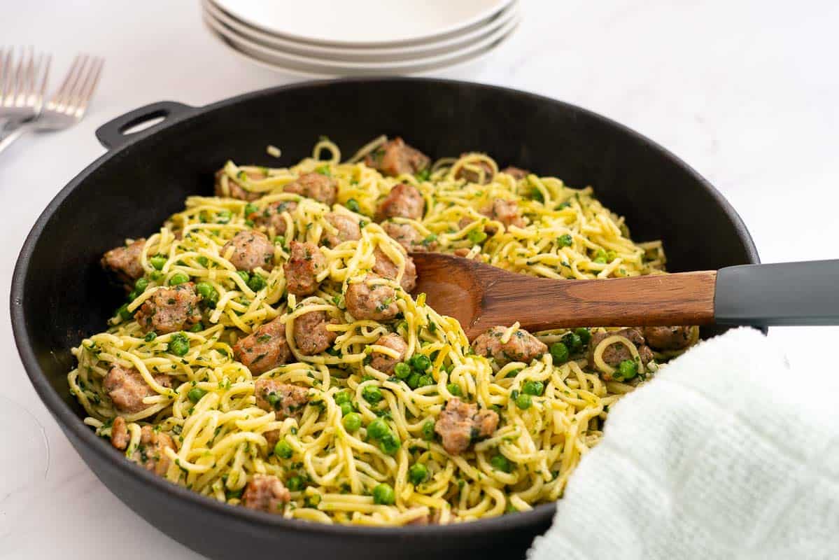 Golden Fried Spaghetti in a large skillet with sausage peas and spinach