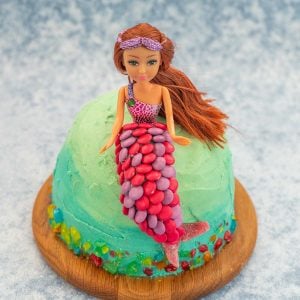 Ombre ocean coloured cake with a mermaid cake topper decorated with colourful sweets