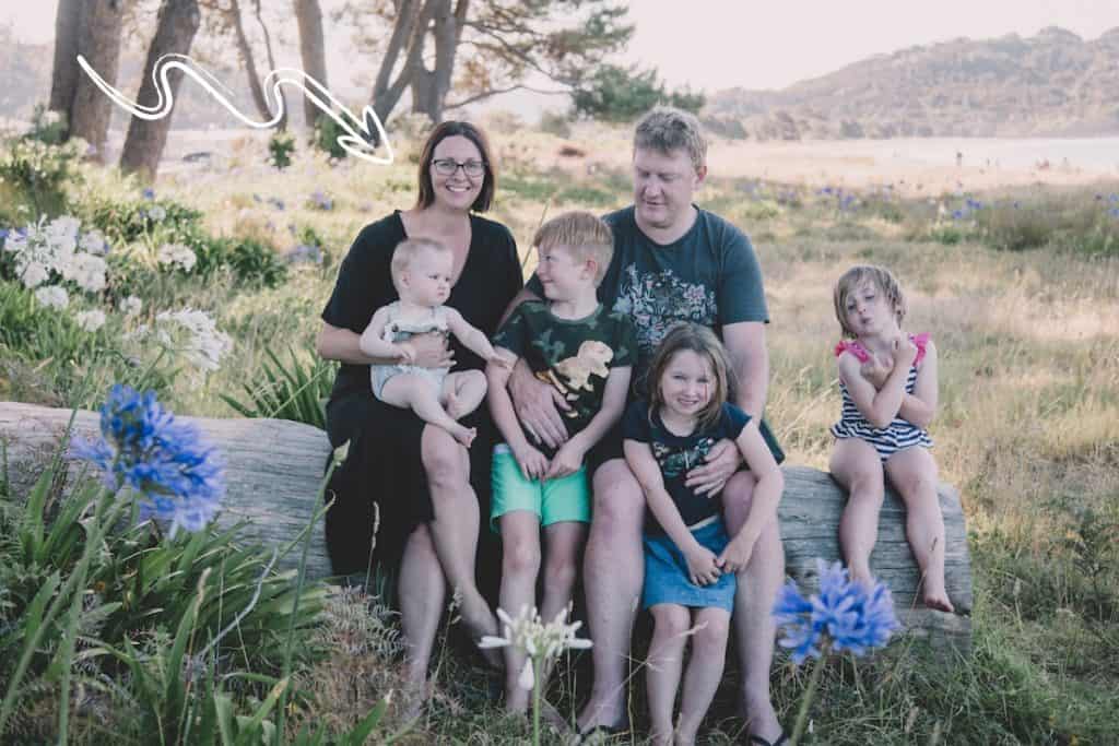 family of 6 sitting on a log, arrow pointing to the mother Stacey Kemeys)