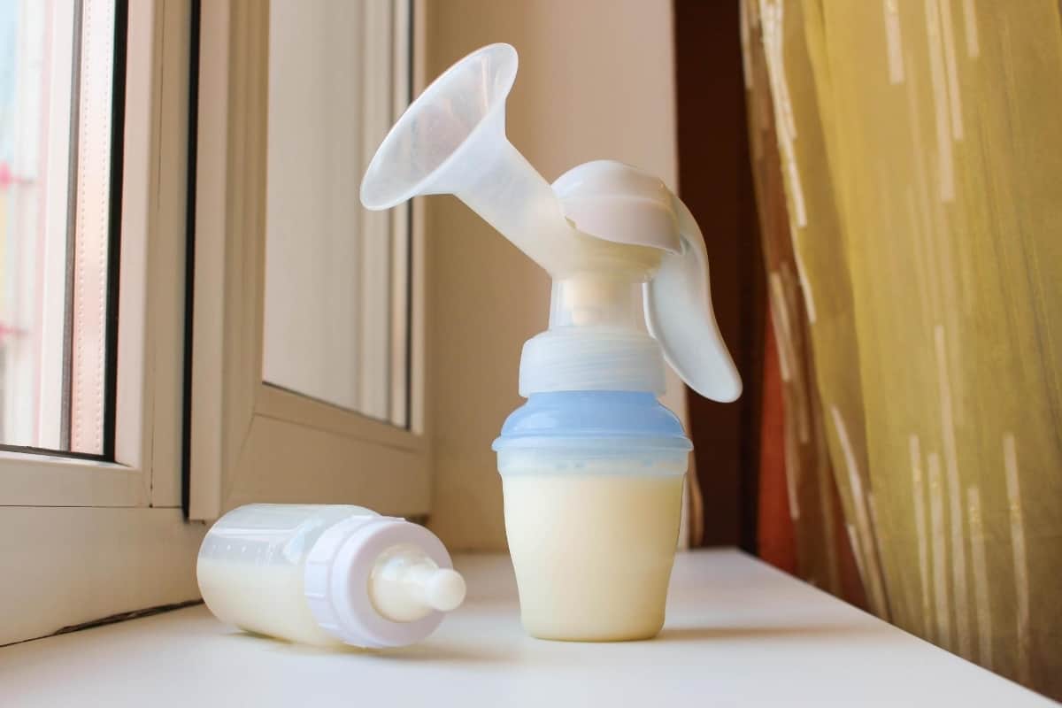breast milk pump and baby bottle full of breastmilk
