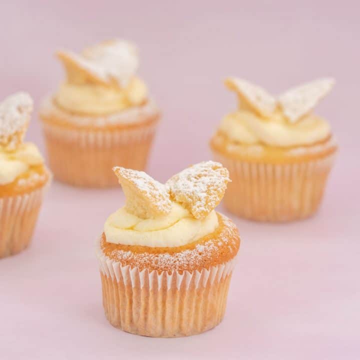 4 butterfly cupcakes on a pink background