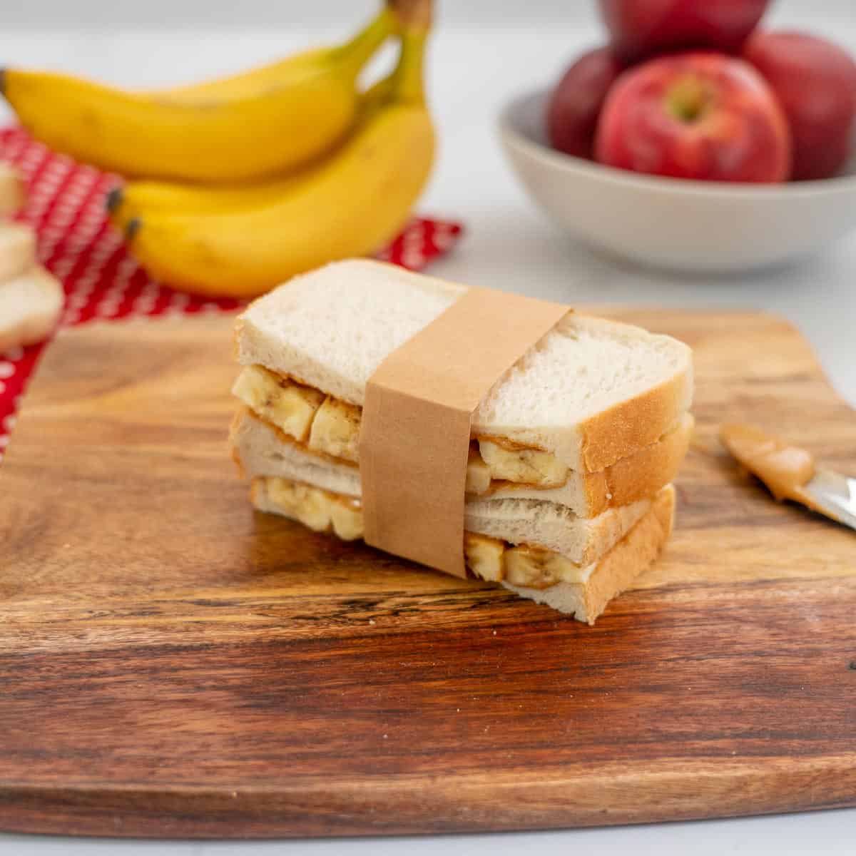 banana and peanut butter sandwich held together with a strip of brown paper