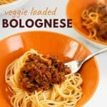 spaghetti bolognese in an orange bowl with text overlay for pinterest