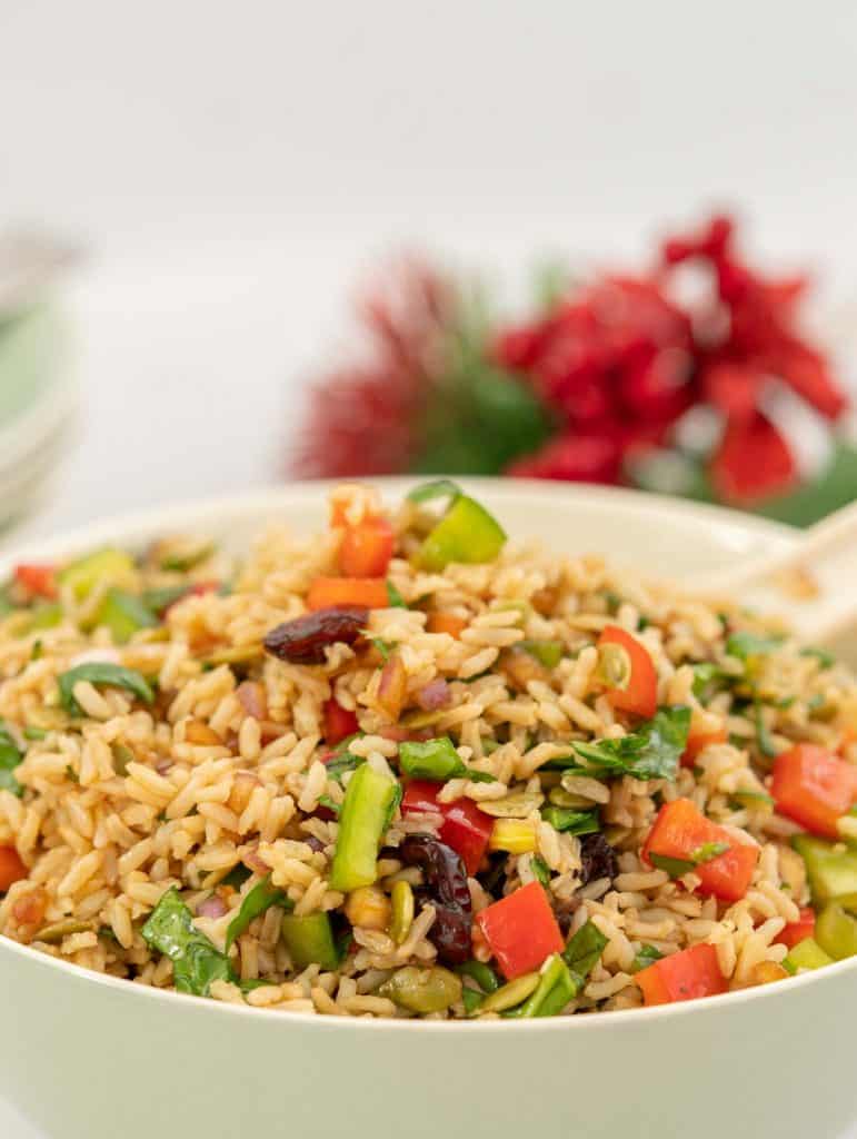 Close up of brown rice salad with red and green ingredients visible