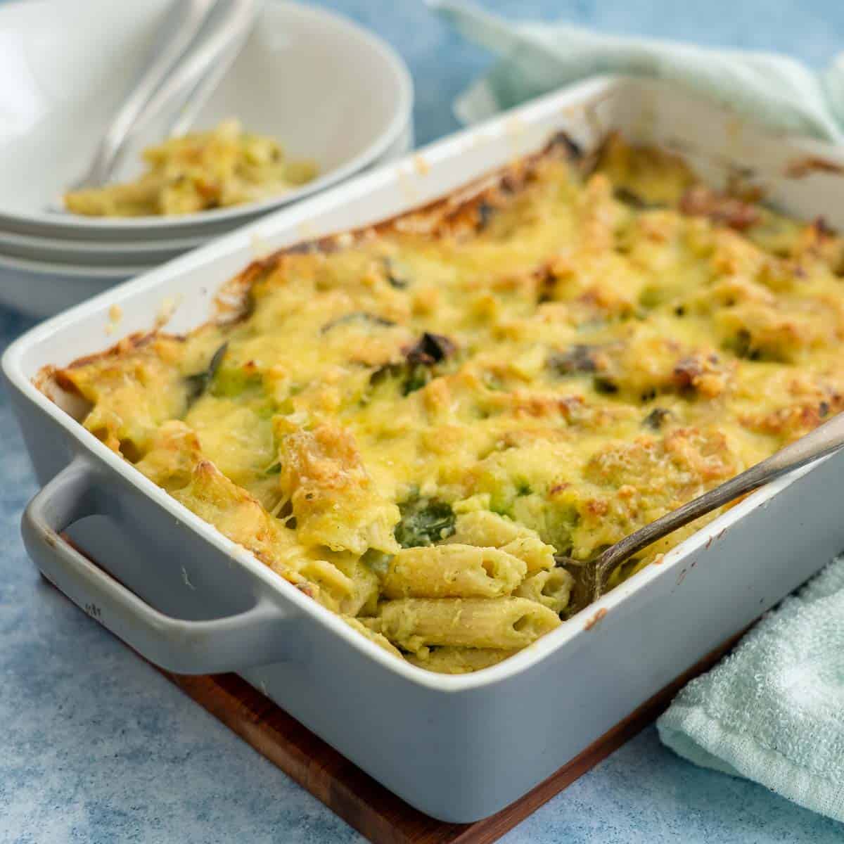 A slate blue rectangular ceramic baking dish filled with a cheesy pasta bake