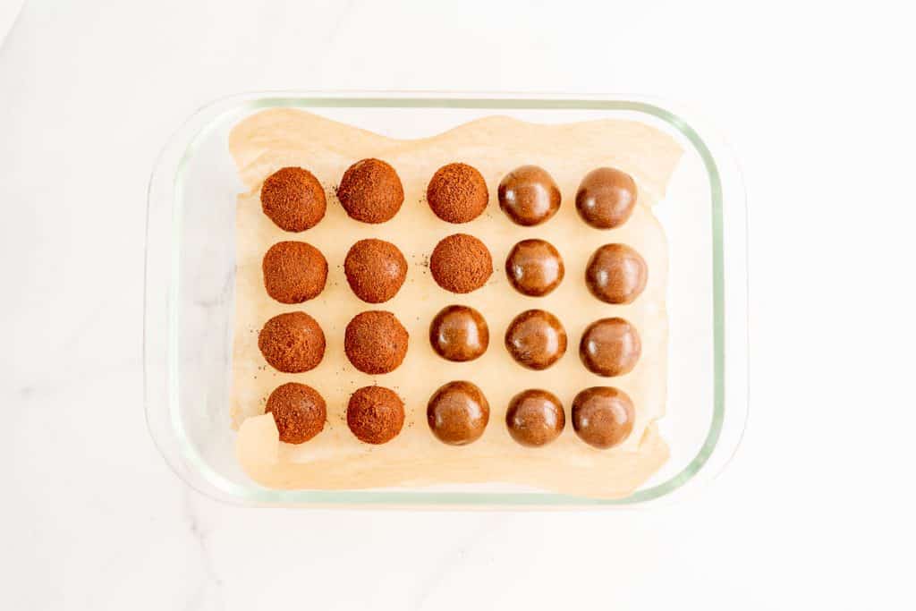 milo balls in a parchment paper lined glass container ready to go in the fridge.