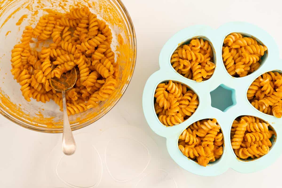 Baby pasta portioned into a blue silicone freezing container ready to freeze.