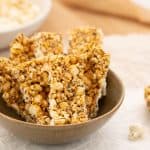Brown ceramic bowl filled with 6 popcorn bars, a bowl of popcorn in the background.