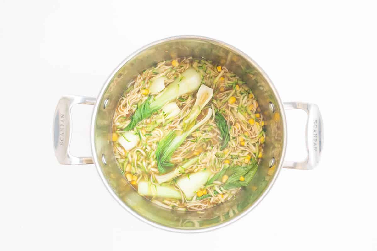 Asian chicken noodle soup in a large soup pot.